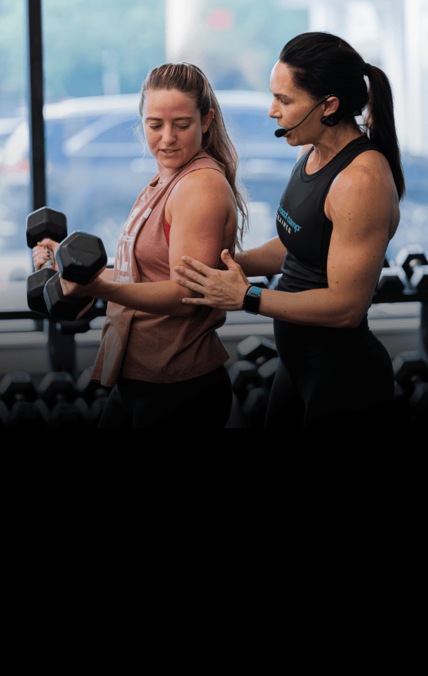 a burn boot camp trainer helps a member